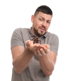Scared man holding tarantula on white background. Arachnophobia (fear of spiders)