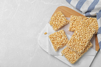 Delicious rice crispy treats on light grey table, flat lay. Space for text