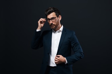 Photo of Handsome bearded man with glasses on black background