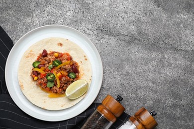 Tasty chili con carne with tortilla on grey table, flat lay. Space for text