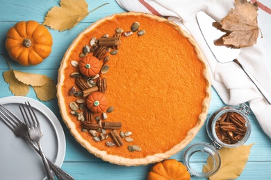 Delicious homemade pumpkin pie on light blue wooden table, flat lay