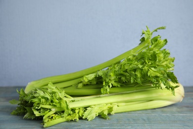 Fresh ripe celery on blue wooden table. Space for text