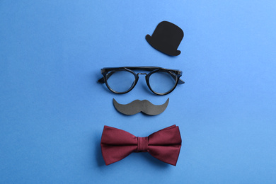 Flat lay composition with glasses and bow tie on blue background. Happy Father's day