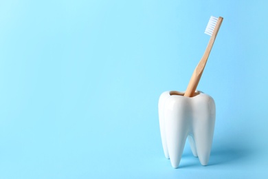 Tooth shaped holder with brush on color background. Space for text