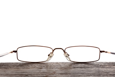 Glasses on wooden table against white background. Ophthalmologist consultation
