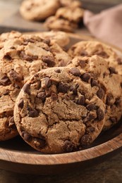 Wooden plate with delicious chocolate chip cookies, closeup