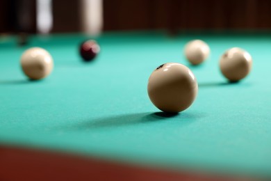 Photo of Many billiard balls on green table indoors, closeup