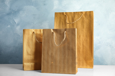 Gold shopping paper bags on white table