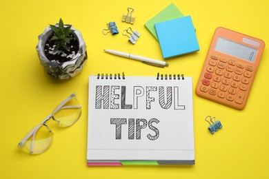 Helpful Tips. Flat lay composition with notebook and calculator on yellow background
