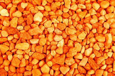 Pile of orange stones as background, top view