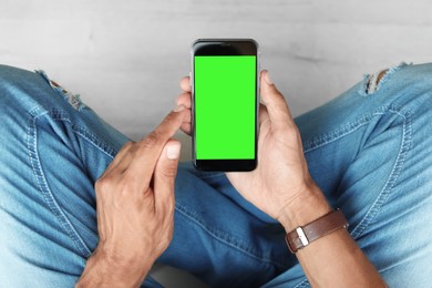 Image of Man using smartphone with green screen, closeup. Gadget display with chroma key. Mockup for design
