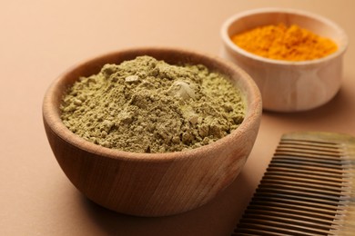 Photo of Comb, henna and turmeric powder on beige background, closeup. Natural hair coloring