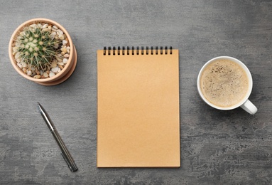 Flat lay composition with notebook and cup of coffee on grey background