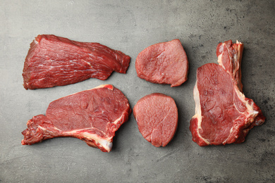 Flat lay composition with different fresh beef cuts on grey table