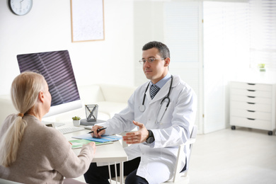 Doctor consulting patient at desk in clinic