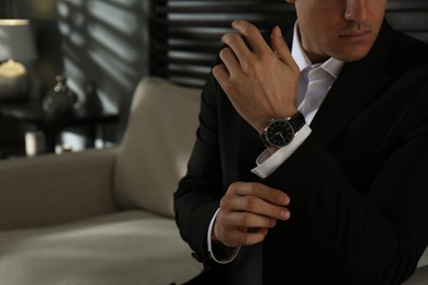 Businessman with luxury wrist watch indoors, closeup. Space for text