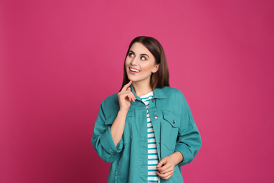 Portrait of happy young woman on pink background