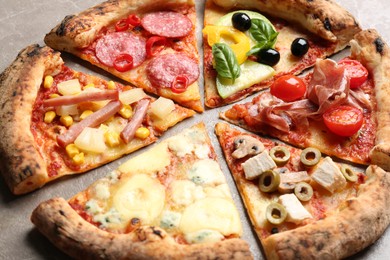 Photo of Slices of different delicious pizzas on table, closeup