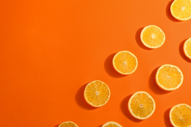 Slices of delicious oranges on color background, flat lay. Space for text