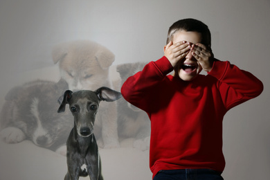 Scared little boy suffering from cynophobia on beige background. Irrational fear of dogs