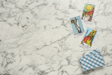 Tarot cards on white marble table, flat lay. Space for text