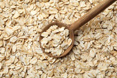 Closeup of wooden spoon on oatmeal, top view
