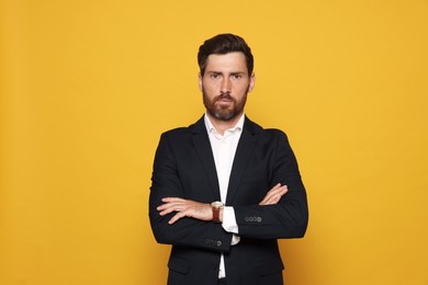 Photo of Portrait of bearded man in suit on orange background
