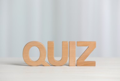 Word Quiz made with wooden letters on white table