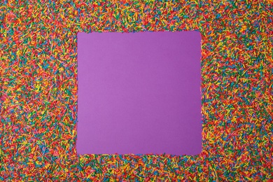 Frame of sprinkles on purple background, flat lay with space for text. Confectionery decor