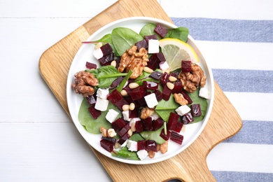 Delicious beet salad served on white wooden table, top view