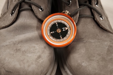 Small compass and hiking boots, closeup. Camping items