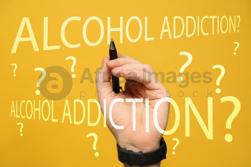 Alcohol addiction? - We can help you. Closeup view of man with pen against yellow background