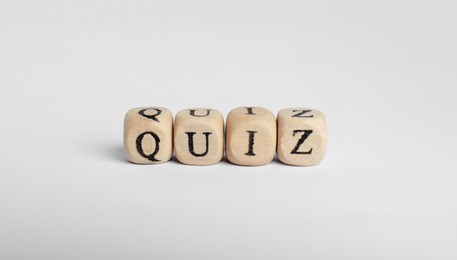 Wooden cubes with word Quiz on white background