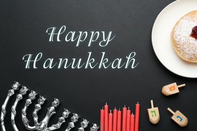 Happy Hanukkah. Traditional menorah, candles, sufganiyah and dreidels on black background, flat lay 