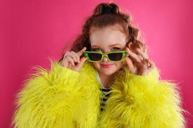 Cute indie girl with sunglasses on pink background