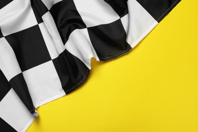 Checkered finish flag on yellow background, top view. Space for text