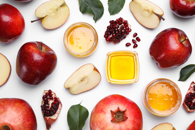 Honey, apples and pomegranates on white background, flat lay. Rosh Hashanah holiday