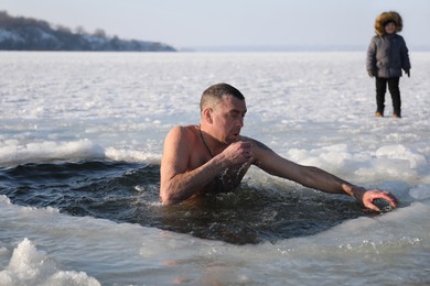 MYKOLAIV, UKRAINE - JANUARY 06, 2021: Man immersing in icy water on winter day