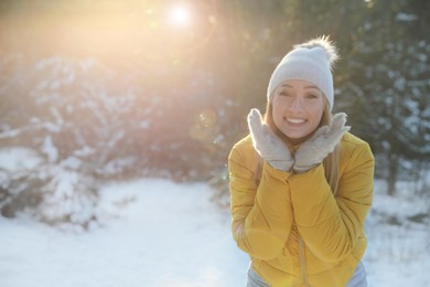 Woman enjoying winter day in forest, space for text