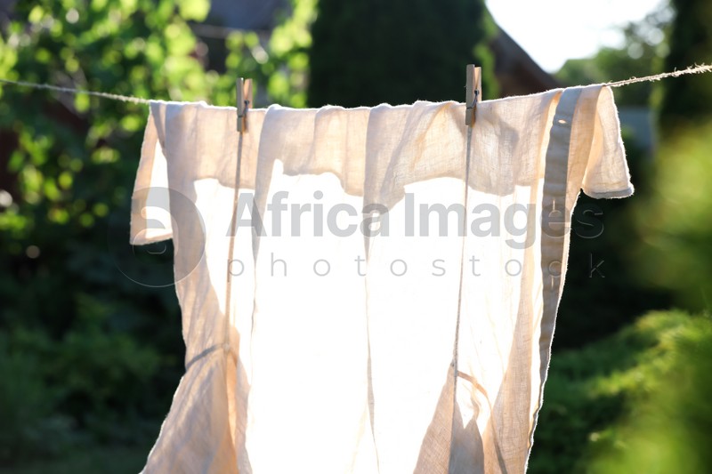 Photo of Shirt drying on washing line against blurred background, closeup