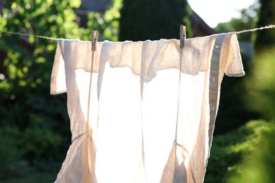 Shirt drying on washing line against blurred background, closeup