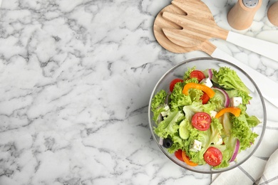 Tasty fresh Greek salad on white marble table, flat lay. Space for text