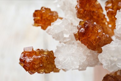 Photo of Different sugar crystals on light background, closeup. Tasty rock candies
