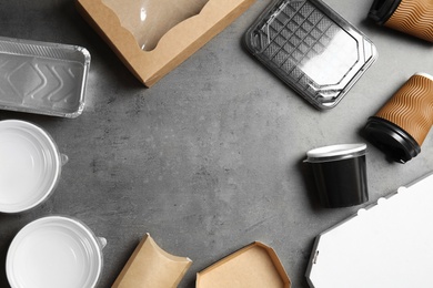 Frame of different takeout containers and space for text on grey background, flat lay. Food delivery service