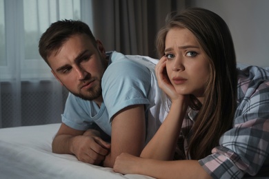 Young couple with relationship problems in bed at nighttime