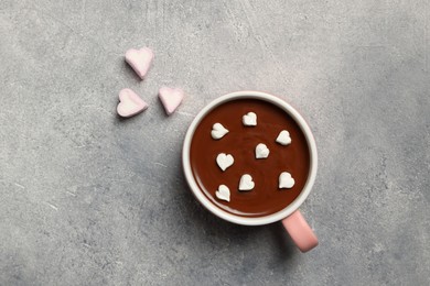 Photo of Cup of hot chocolate with heart shaped marshmallows on light grey table, flat lay