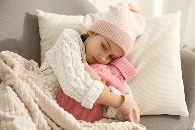 Ill girl with hot water bottle suffering from cold at home