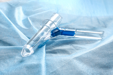 Anoscope on light blue fabric. Hemorrhoid treatment
