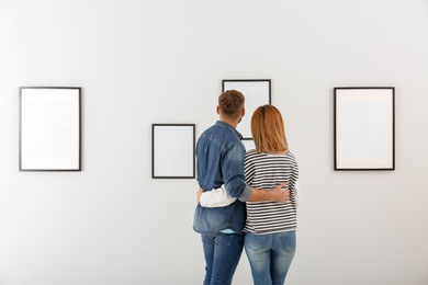 Couple viewing exposition in modern art gallery
