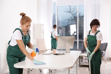 Team of professional janitors working in modern office. Cleaning service